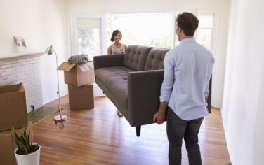 Picture of a Melbourne family moving into their home, holding a couch