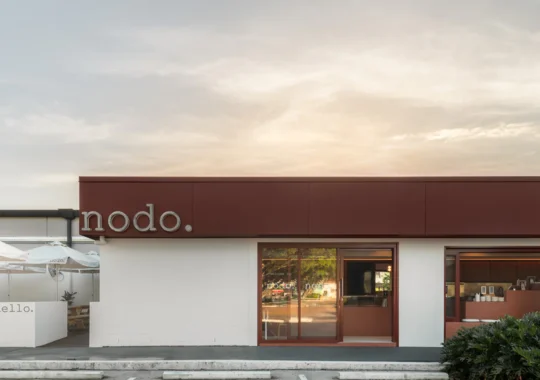 Image shows a sun setting over a cafe which is Nodo Everton Park with empty car parks out the front